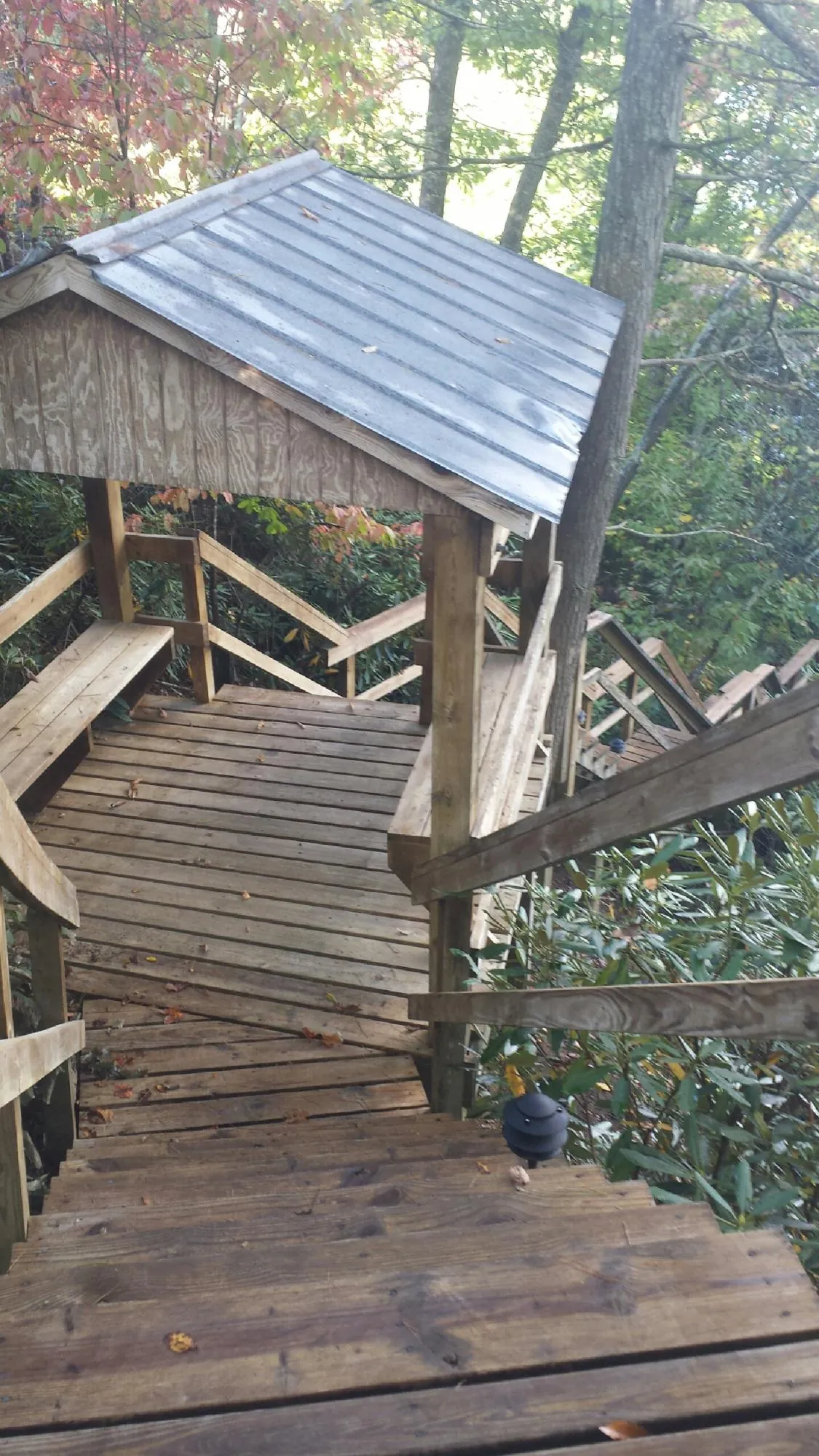 Metal roofed shelter over wooden steps on a wooded walkway — Skylight Repair & Installation work by our crew in Guys Mills