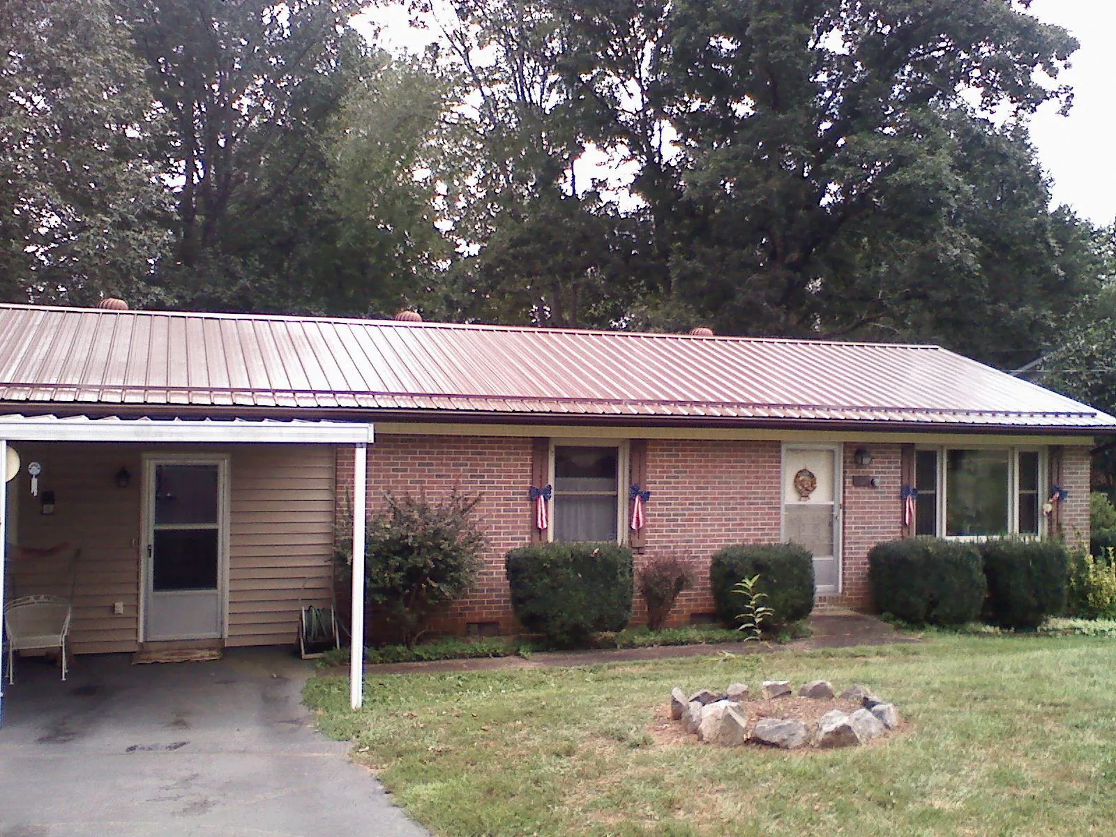 Bronze metal roof and carport on a brick ranch home — Roof Repair work by our crew in Guys Mills